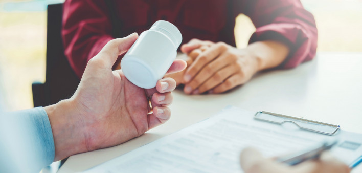 doctor handing bottle of pills to patient