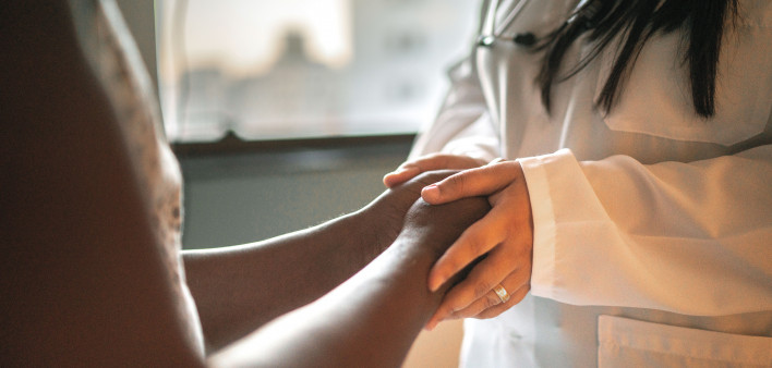 Doctor holding patients hands
