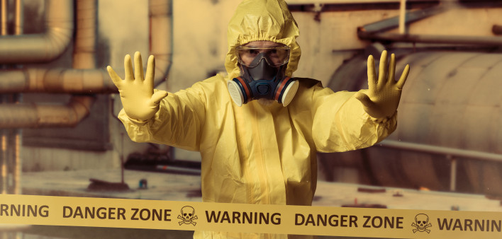 man in protective yellow gear and gas mask danger zone