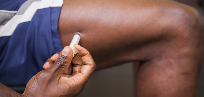 Close up of muscular man injecting steroids in the gym testosterone