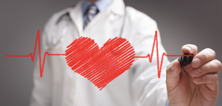 doctor in white coat drawing a red heart on glass