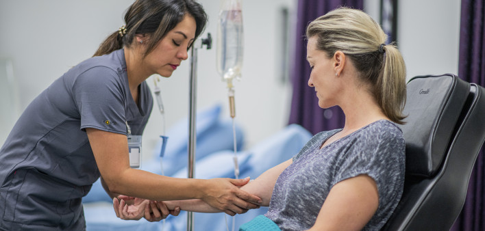 Female Doctor giving intravenous drip treatment to a female patient