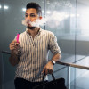 Young latino man e-cigarette smoking