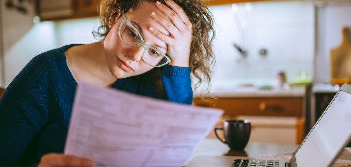 Woman going through bills, looking worried