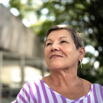 senior hispanic woman looking off into distance with a slight smile
