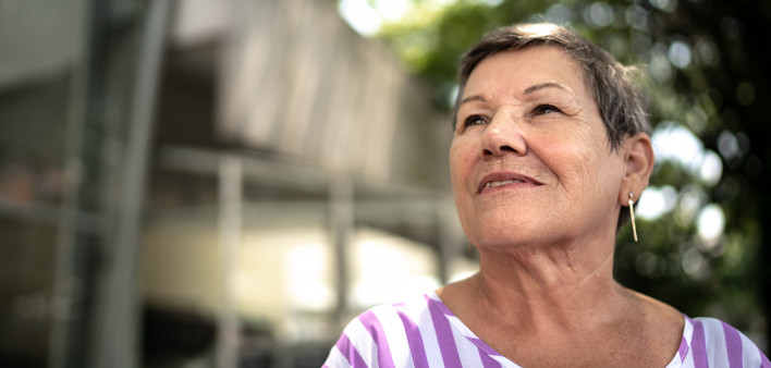 senior hispanic woman looking off into distance with a slight smile