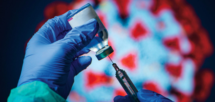 gloved hand needle vial vaccine coronavirus