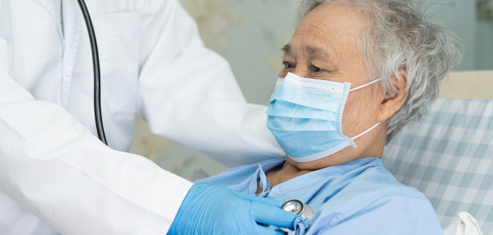 Asian senior or elderly old lady woman patient wearing a face mask in hospital for protect infection and kill Novel Coronavirus (2019-nCoV) Covid-19 virus.