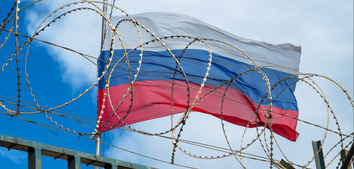 Russian flag behind barbed wire against cloudy sky stock photo Russia, Authority, Prison,