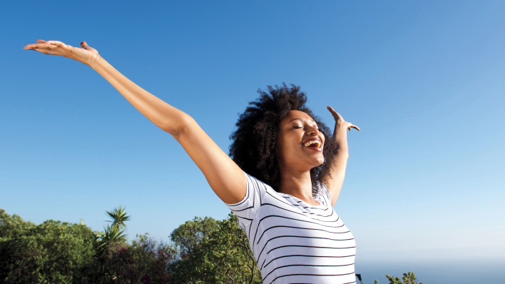 woman outside arms stretched happy