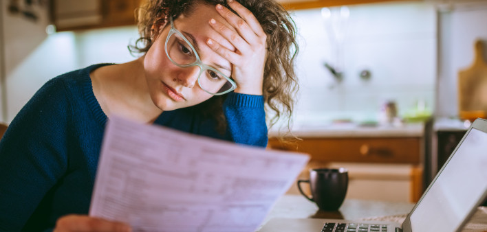 Woman going through bills, looking worried