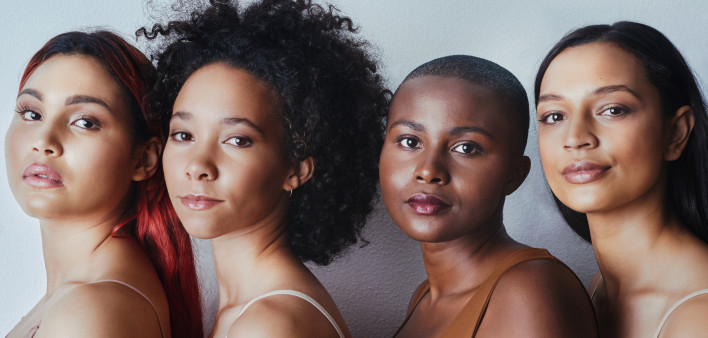 Black women tudio shot of a group of beautiful young women posing together against a gray background