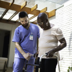 Home caregiver helping senior woman to walk