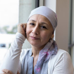 A peaceful photo of a breast cancer patient wearing a scarf to cover her head.