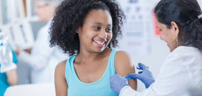 young woman getting s shot from a nurse