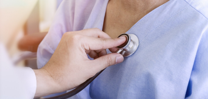 Doctor checking patient's heart with stethoscope at a hospital