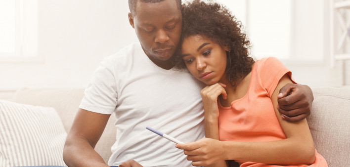 african american couple black looking at pregnancy test