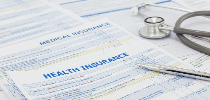Medical insurance application, silver pen and stethoscope. Legal law contract and health insurance concepts.