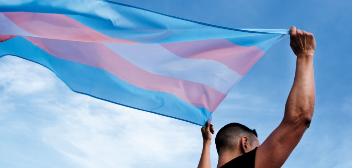 Young person with a transgender pride flag