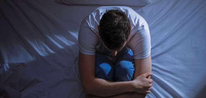 depressed young man in bed dark depresssion isolation