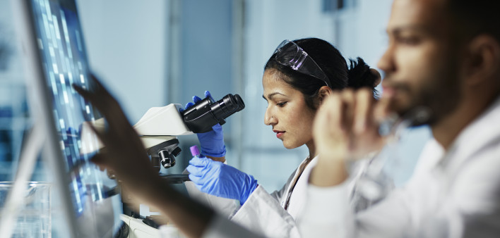 Scientist Working on Computer In Modern Laboratory all graps, dna models,