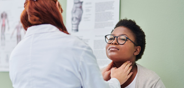 black woman getting thyroid exam