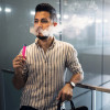 Young latino man e-cigarette smoking