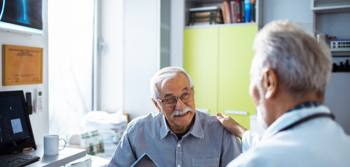 Doctor with x-rays and smiling old man patient