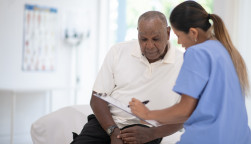 nurse helping patient fill out papers