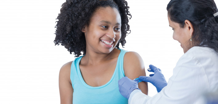 girl receiving vaccine from female doctor