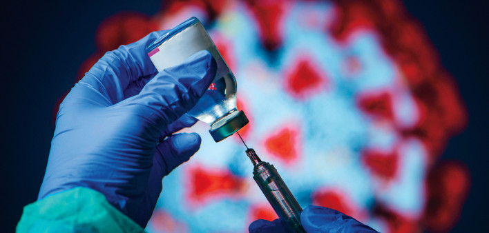 gloved hand needle vial vaccine coronavirus
