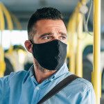 Men with protective face mask traveling with bus, during COVID-19
