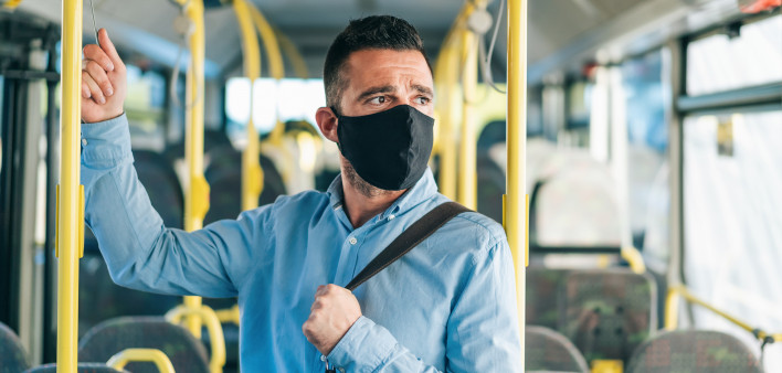 Men with protective face mask traveling with bus, during COVID-19