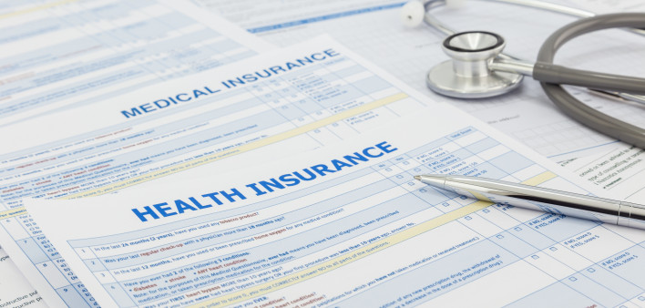 Medical insurance application, silver pen and stethoscope. Legal law contract and health insurance concepts.