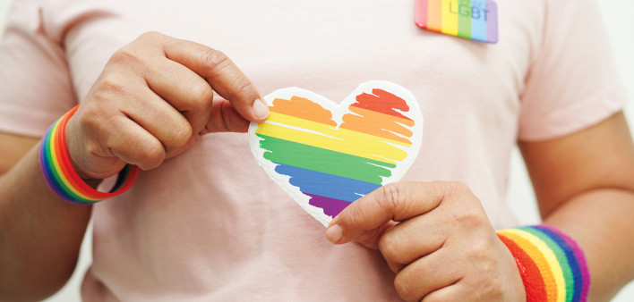 hands holding LGBT colored heart
