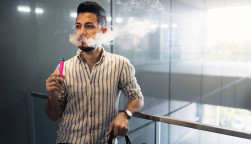oung hispanic businessman smoking an electronic cigarette