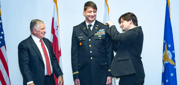 The commissioning of Nick Harrison, center, as an officer in the U.S. Army in Washington, DC, on August 5. Lambda Legal CEO Kevin Jennings, left, attends.