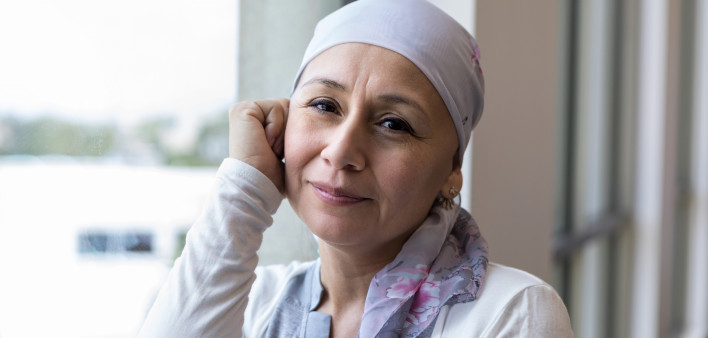 A peaceful photo of a breast cancer patient wearing a scarf to cover her head.