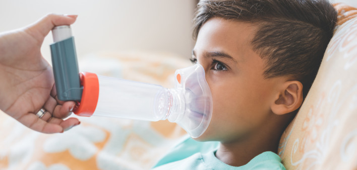 Woman with son doing inhalation with nebulizer at home