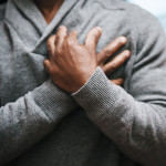 African American Man holding chest pain heart