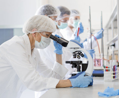 Scientists in protective suits in a science laboratory study a virus