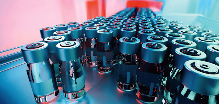 vials of vaccine on assembly line factory