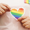 hands holding LGBT colored heart