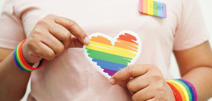 hands holding LGBT colored heart