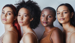 Black women tudio shot of a group of beautiful young women posing together against a gray background
