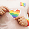 hands holding LGBT colored heart