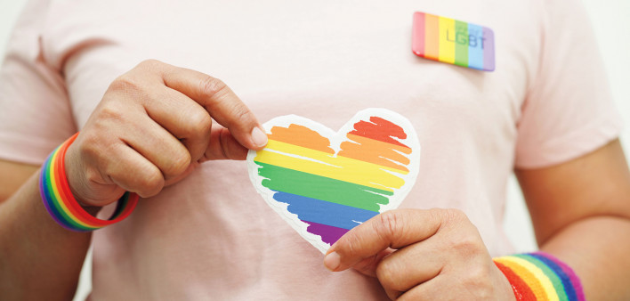 hands holding LGBT colored heart
