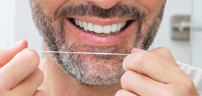 man flossing teeth