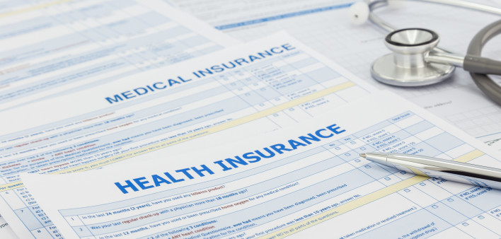 Medical insurance application, silver pen and stethoscope. Legal law contract and health insurance concepts.