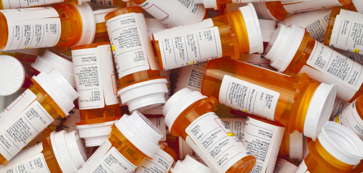Dozens of prescription medicine bottles in a jumble. This collection of pill bottles is symbolic of the many medications senior adults and chronically ill people take.
